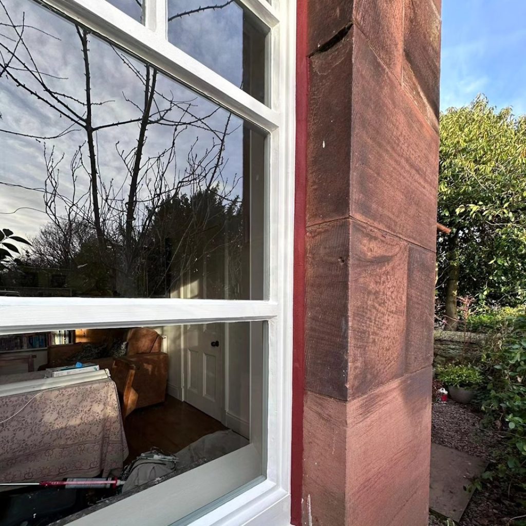 Externally painted window with white paint and red mastic