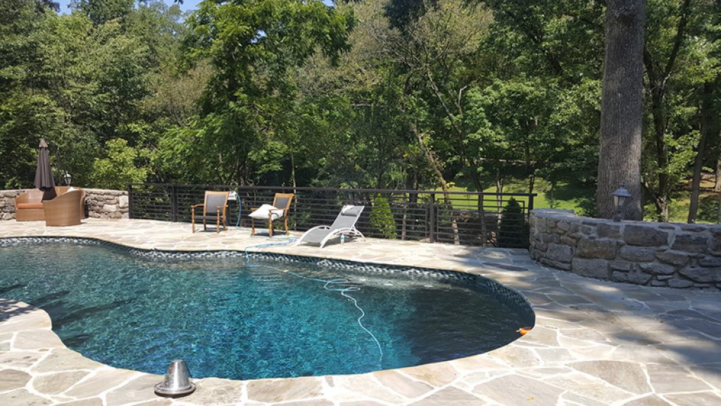 CA pool barrier fence installed on stone facade.jpg