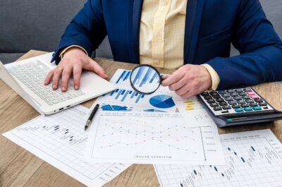 businessman-analyzing-business-graphs-with-magnifying-glass-scaled.jpg